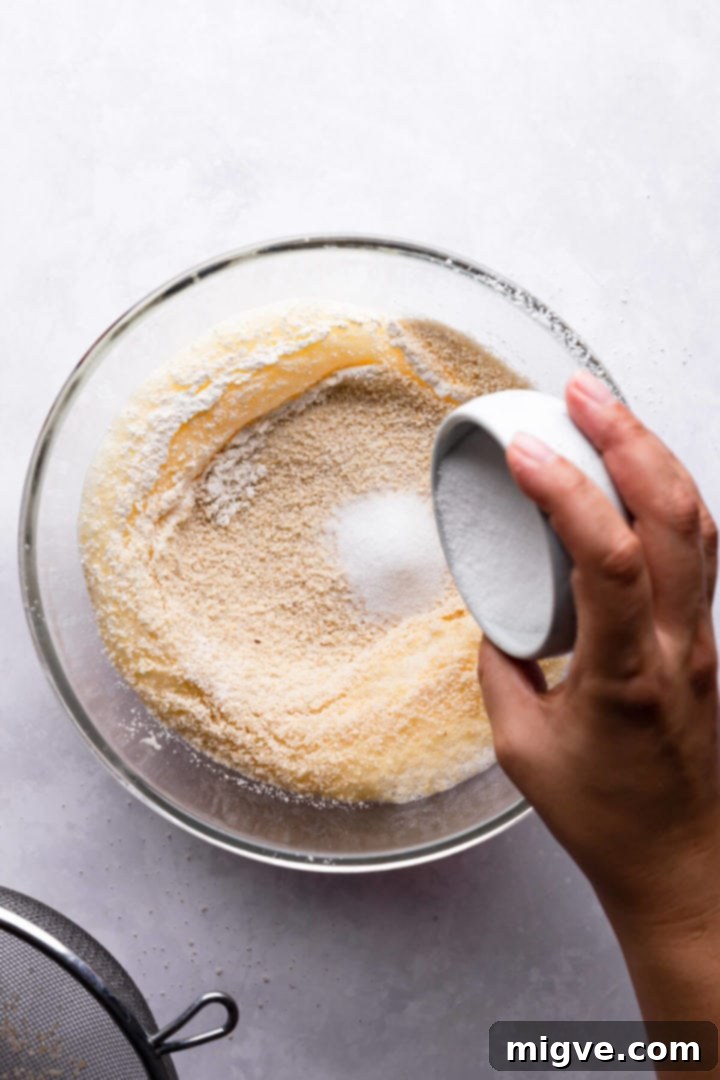top view of sugar being added to the bowl with cake batter