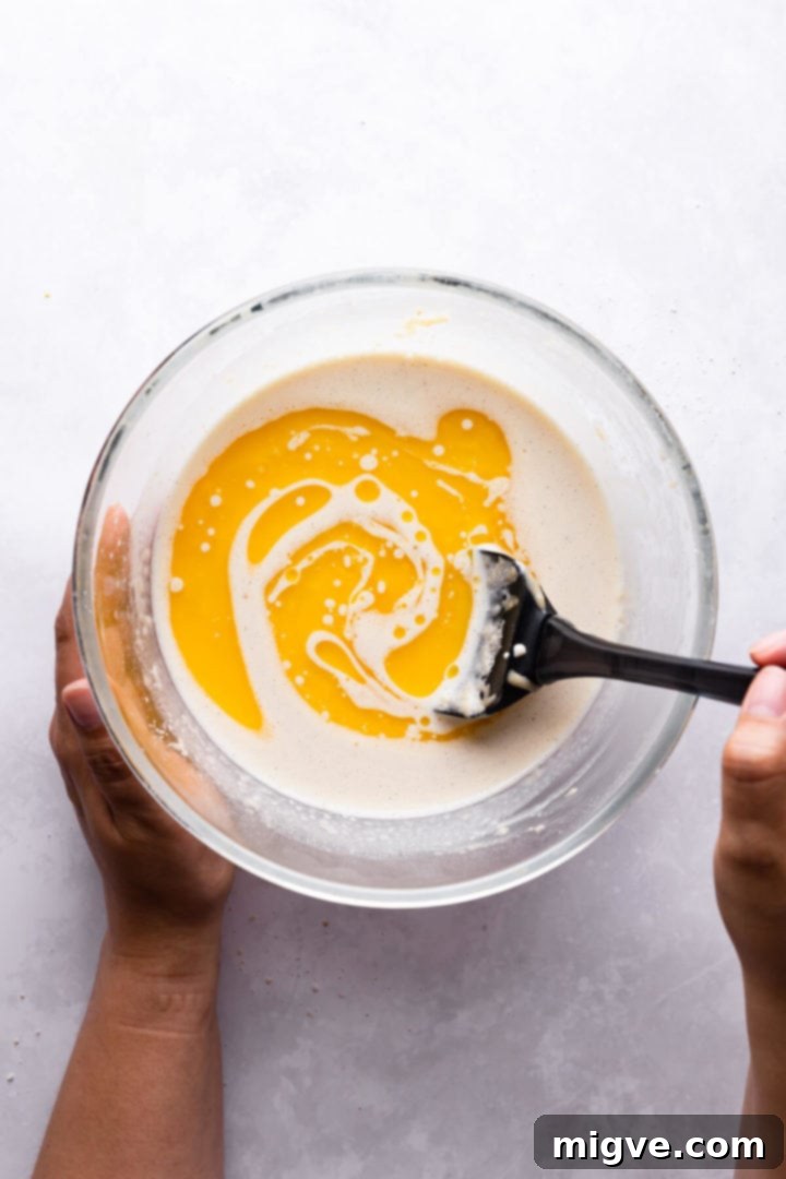 overhead view of melted butter being stirred into clafoutis batter