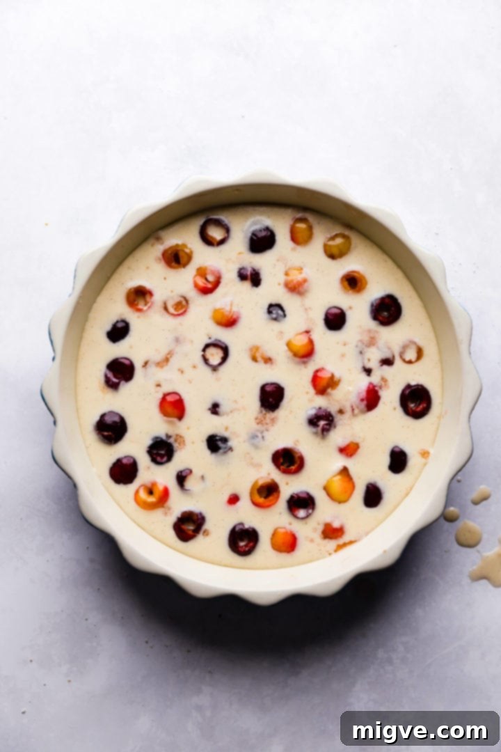 top view of a baking dish filled with cherries and clafoutis batter