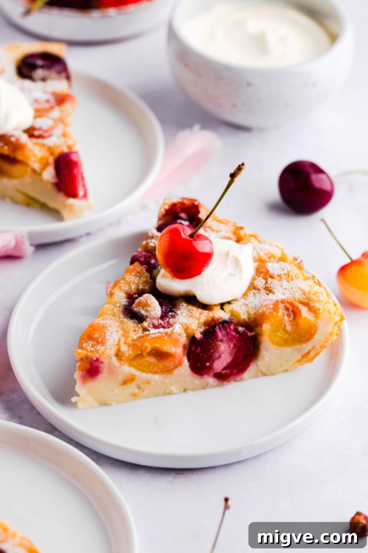 close up of a slice of cherry clafoutis on a small plate