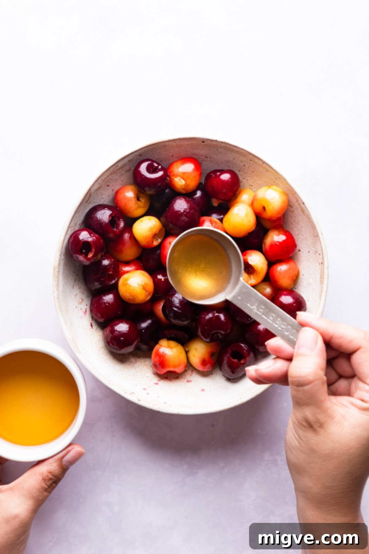 top view of fresh cherries being drizzled with bourbon