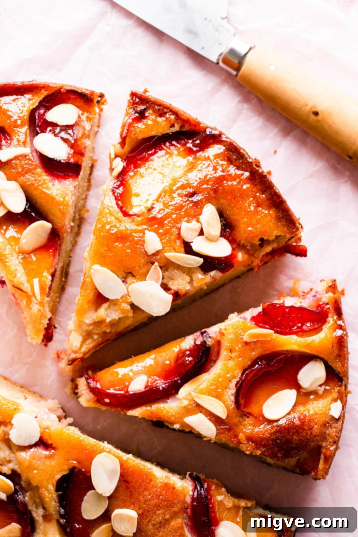 top view super close up at plum cake slices with flaked almonds on top, highlighting the texture