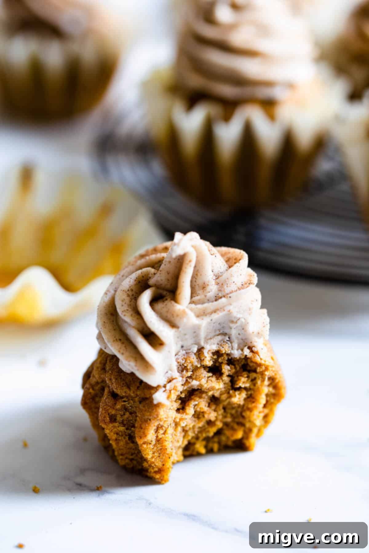 close up of a pumpkin cupcake with a bite taken out of it, showing the moist interior
