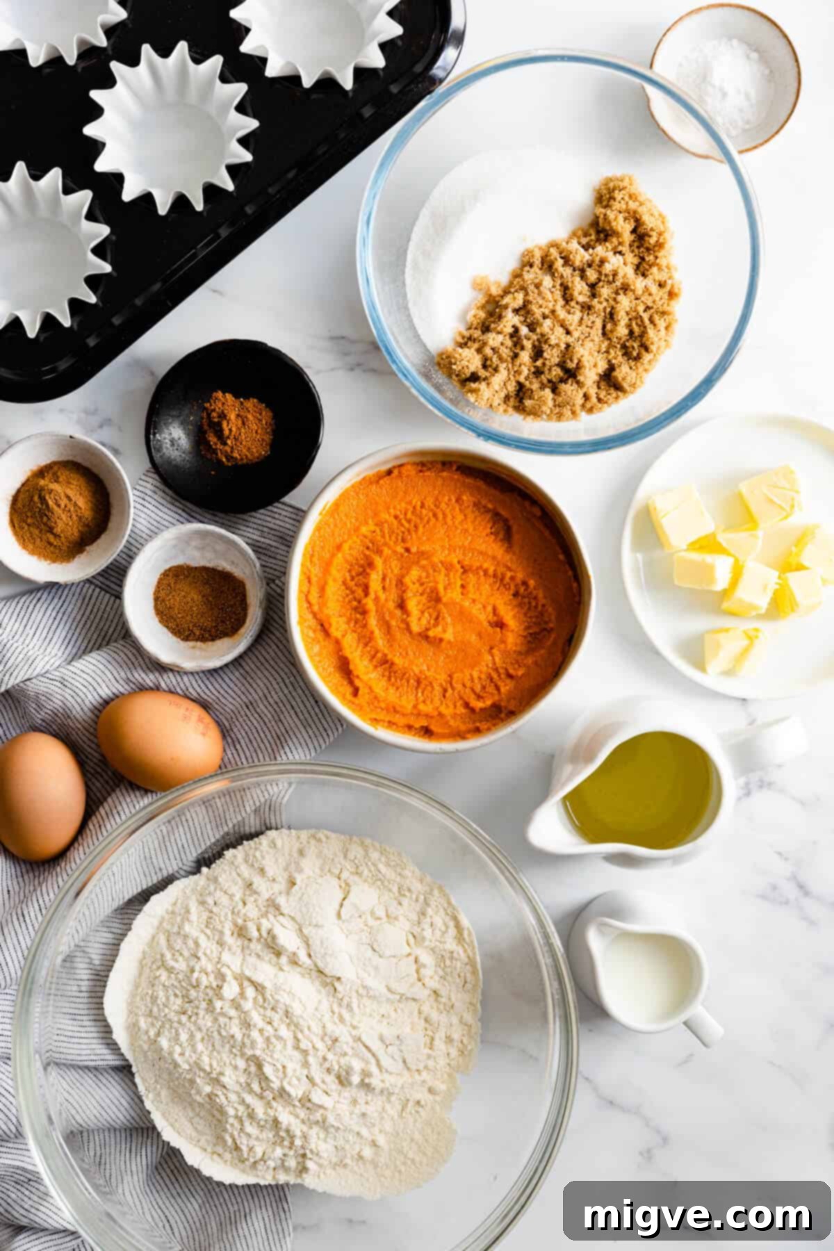 top view of bowls with ingredients for pumpkin and chai cupcakes, neatly arranged