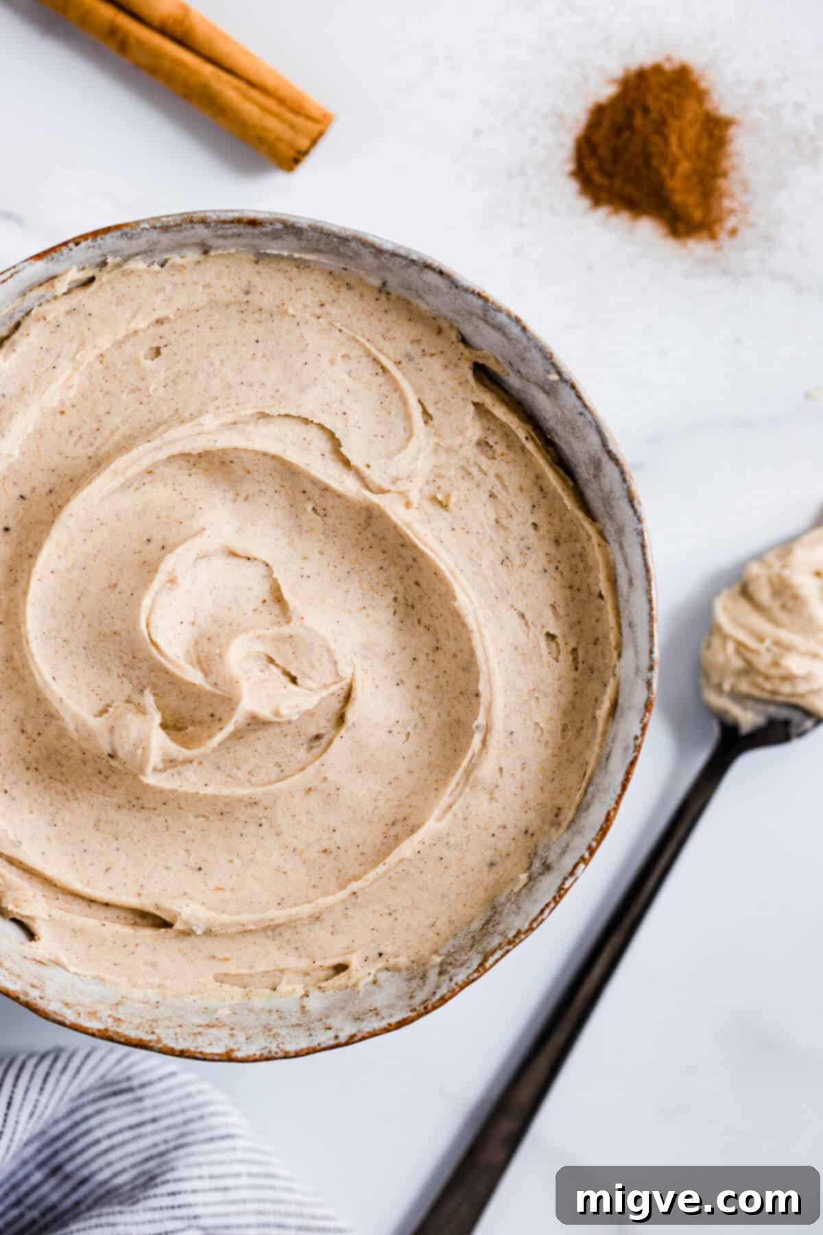 close up of a bowl with creamy chai frosting, ready to be used
