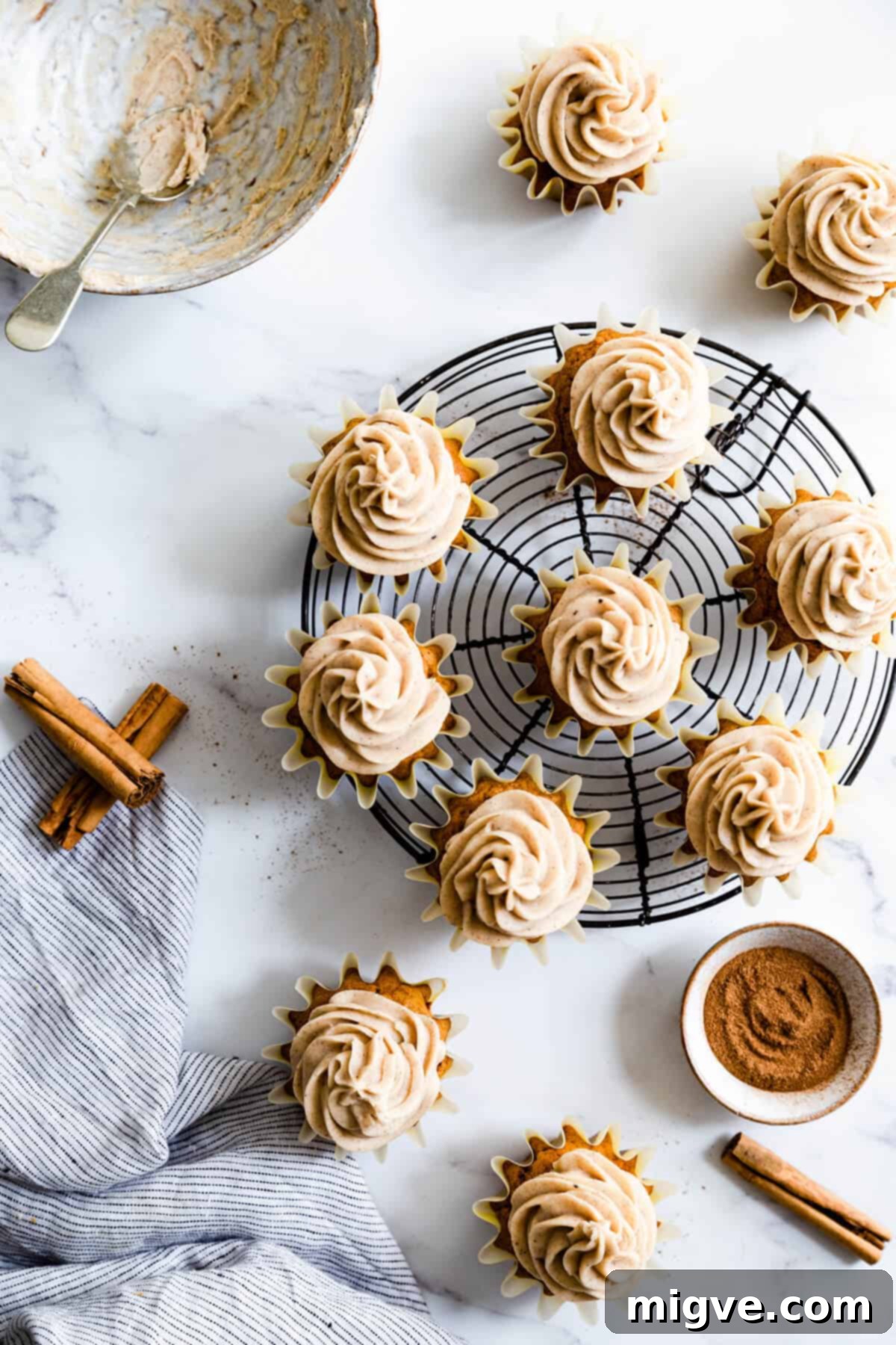 Pumpkin and chai cupcakes arranged on a round cooling rack, ready to be enjoyed