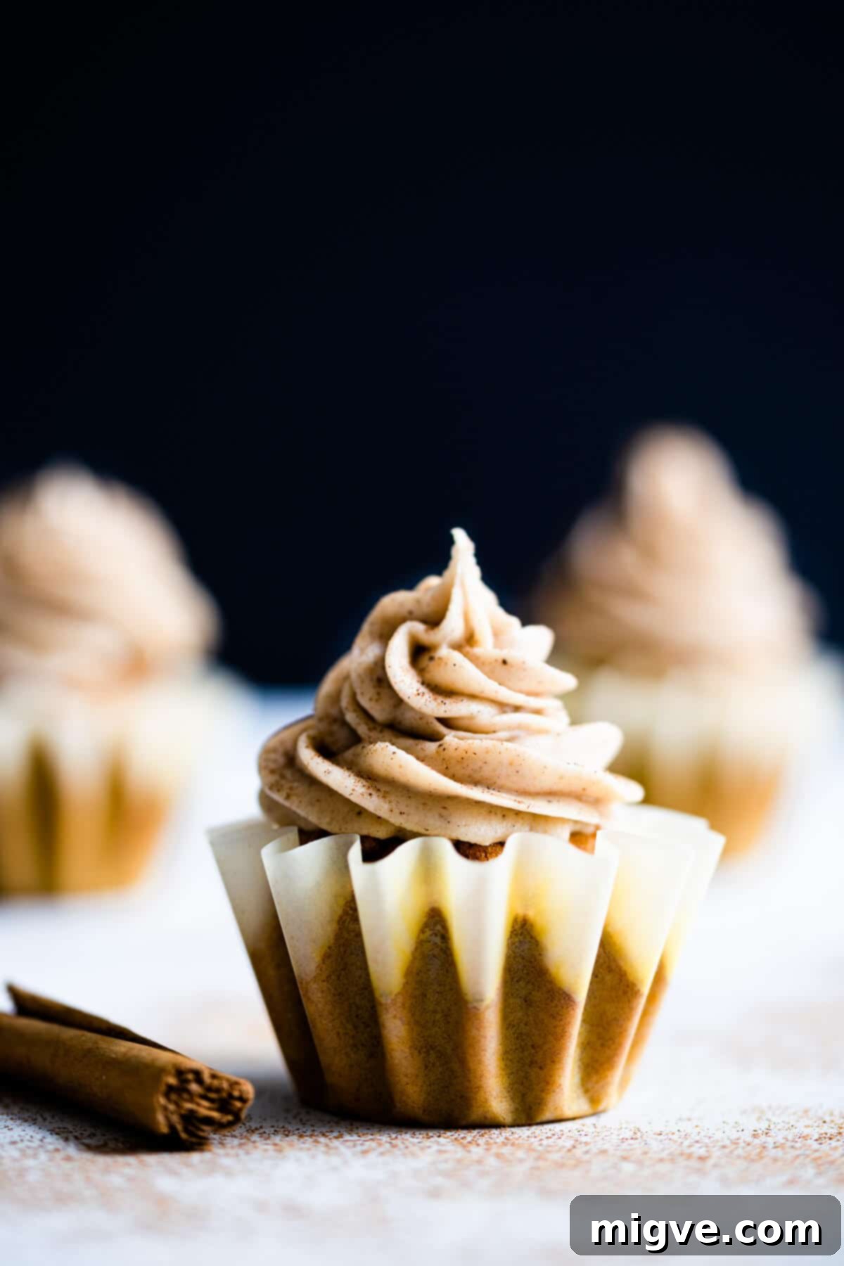 close up of a single pumpkin and chai cupcake sprinkled with cinnamon, highlighting the detail