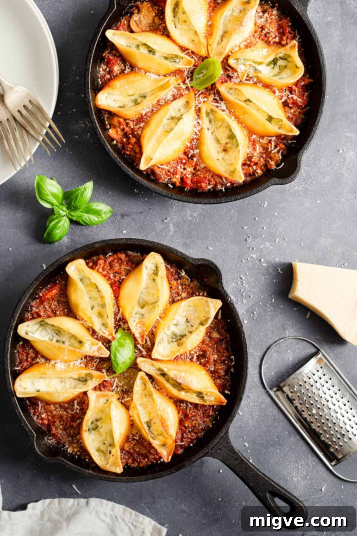 top view of two cast iron pans with stuffed pasta shells bake, freshly baked