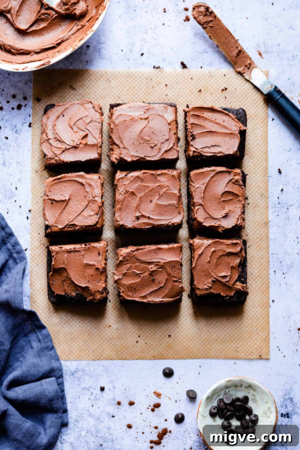 Top view of a dark chocolate traybake with silky frosting, neatly sliced into squares, ready to serve.