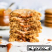 side close up at a stack of dulce de leche stuffed cookies broken into halves