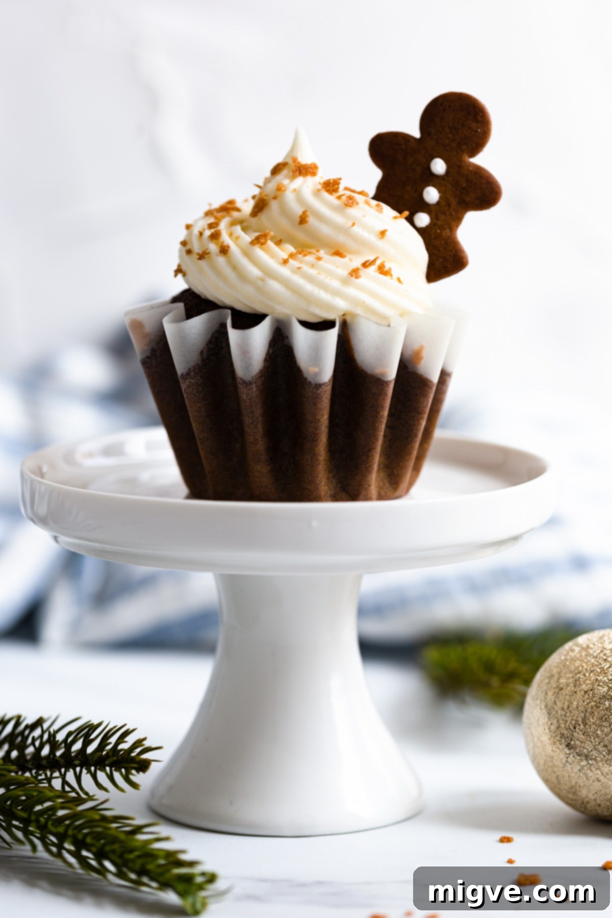 Holiday Gingerbread Delights with Cream Cheese Clouds 7 a side super close up of gingerbread cupcake on a cupcake stand