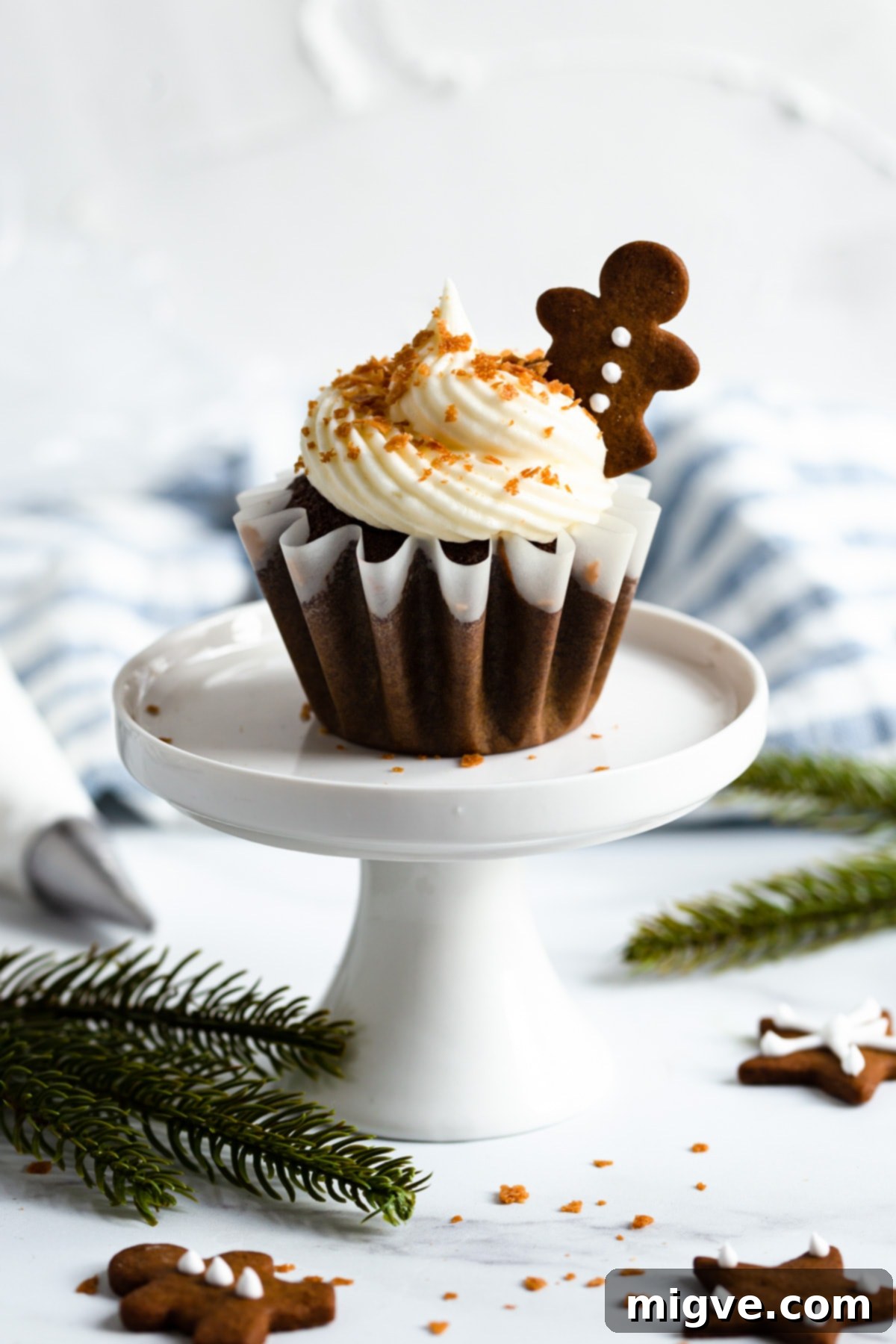 Holiday Gingerbread Delights with Cream Cheese Clouds 9 side shot of a single cupcake with cream cheese frosting on a cupcake stand