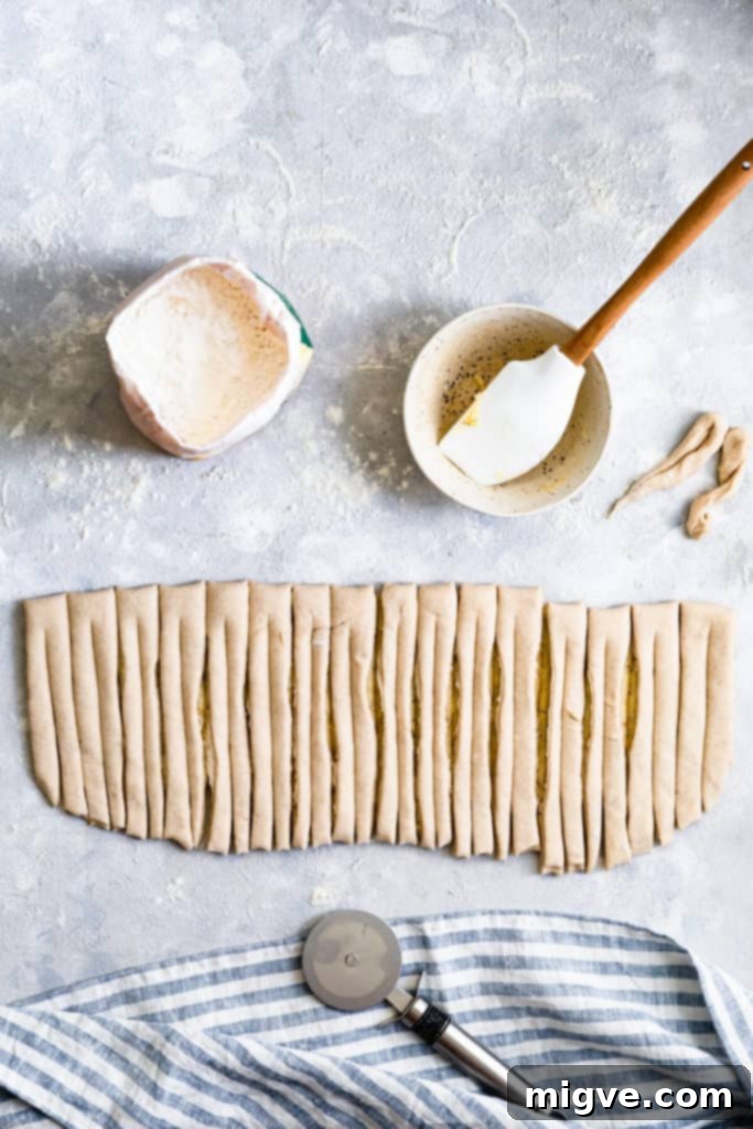 Top-down view of the dough after being sliced into uniform strips, ready for shaping.