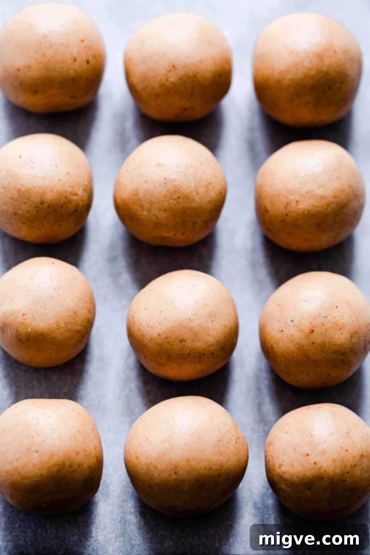 An overhead shot of a batch of freshly prepared 3-ingredient peanut butter energy bites, perfectly round and ready to be chilled.