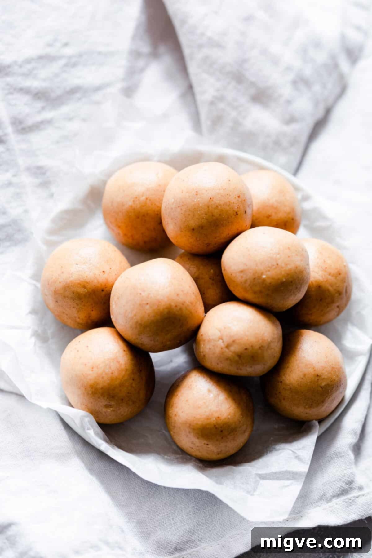 A clean, top-down view of a small stack of 3-ingredient peanut butter energy balls on a plate, ready for serving or storage.