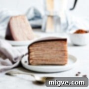 Decadent Chocolate Crepe Dream 16 slice of crepe cake on a small plate with another slice in the backround.