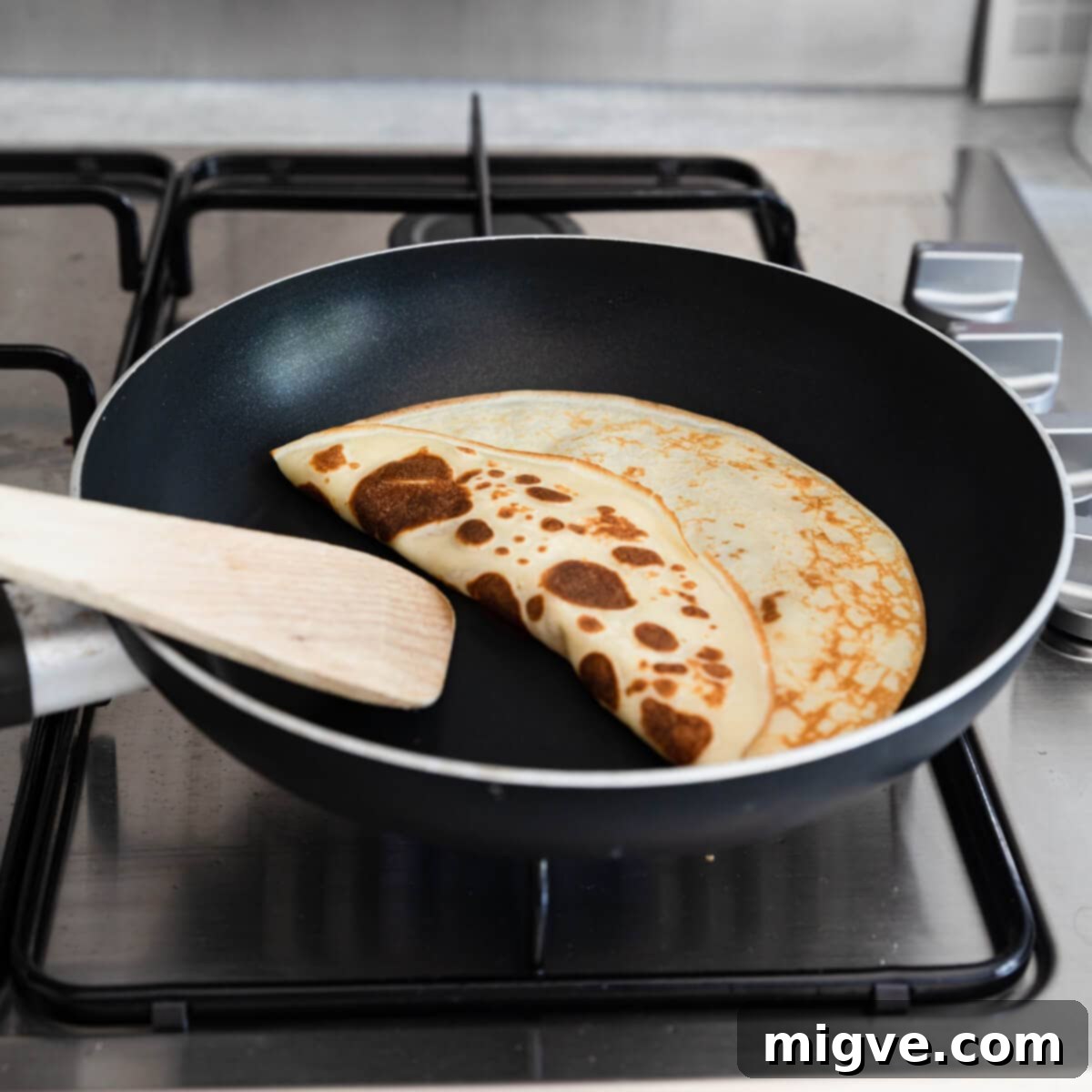 Decadent Chocolate Crepe Dream 7 angle view at a crepe being turned with wooden spatula