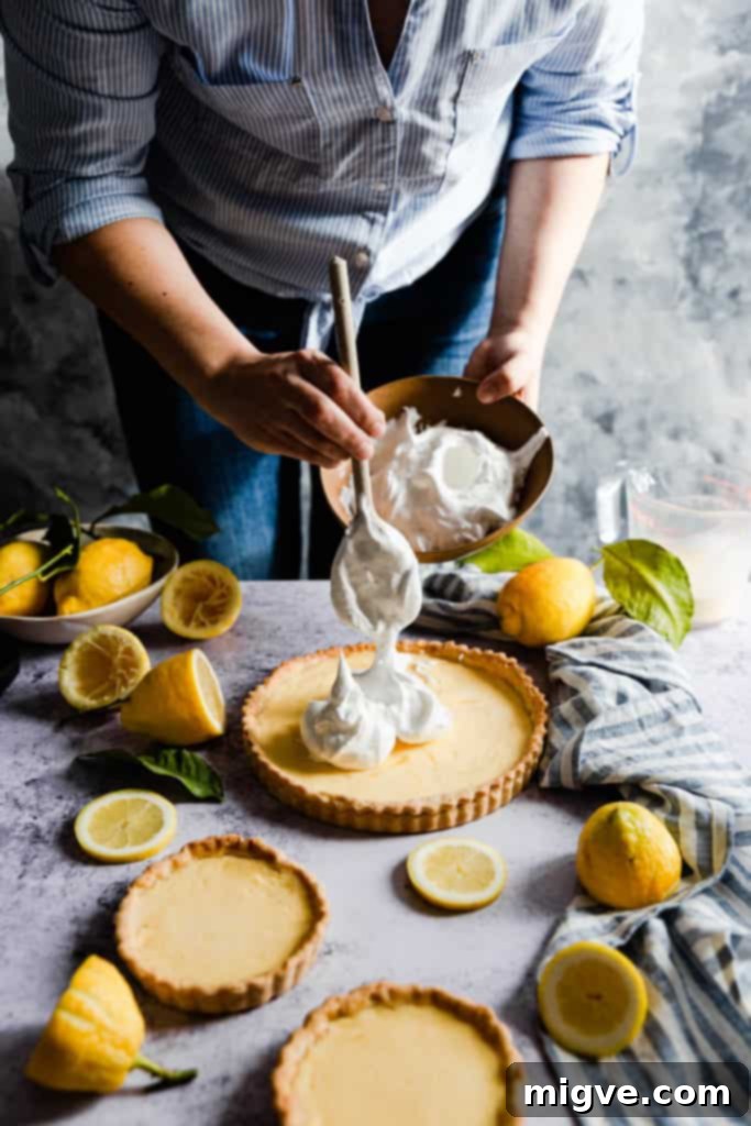 Hot sugar syrup being carefully poured into whisked egg whites in an electric mixer.