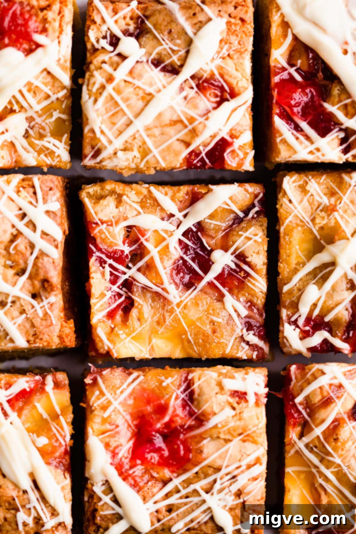 Top view super close-up of beautifully arranged square slices of rhubarb and custard blondies, showing their consistent shape and inviting toppings.