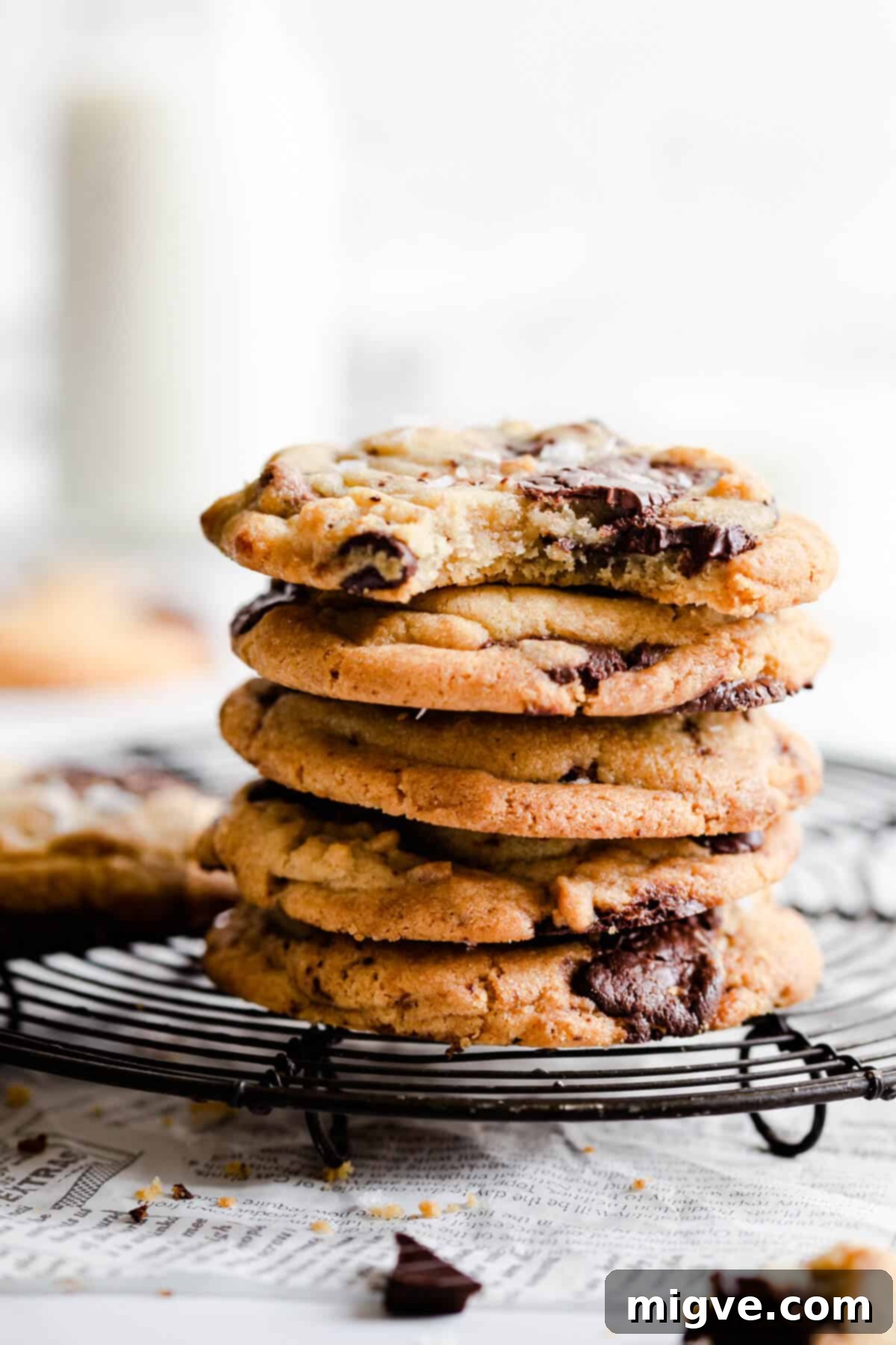 side close up of a stack of cookies with top cookie missing a bite, highlighting the gooey chocolate