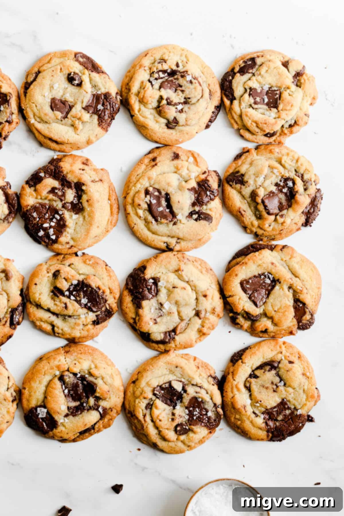 overhead shot of chocolate chip cookies sprinkled with salt on a round rack