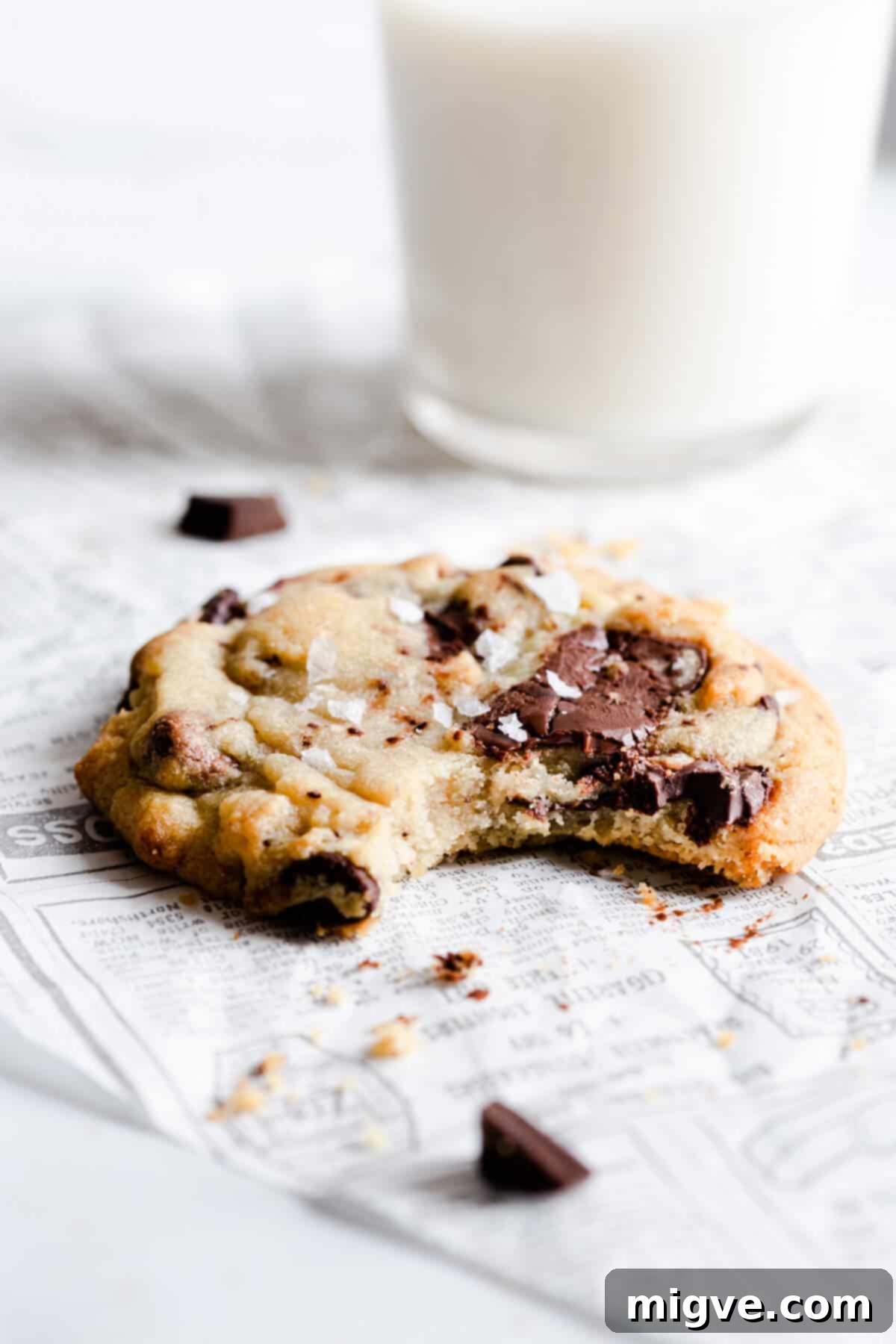 side close up of a chocolate chip cookie with a bite taken out, revealing the soft interior