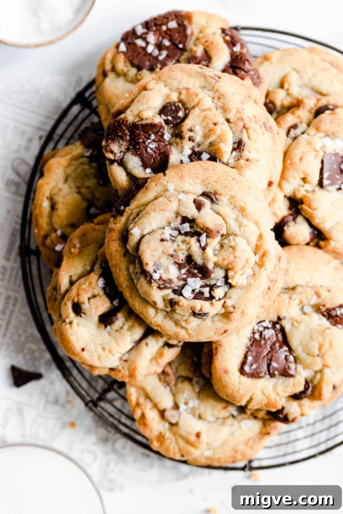 overhead shot of freshly baked chocolate chip cookies cooling on a round wire rack