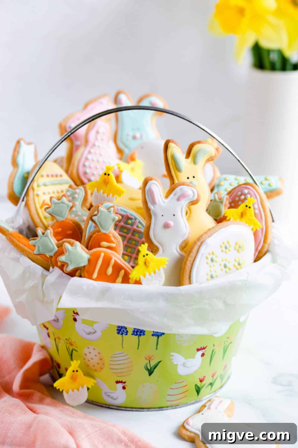 A side close-up of a rustic basket brimming with decorated Easter sugar cookies. The cookies feature intricate designs and pastel royal icing, showcasing various Easter shapes like bunnies and eggs.