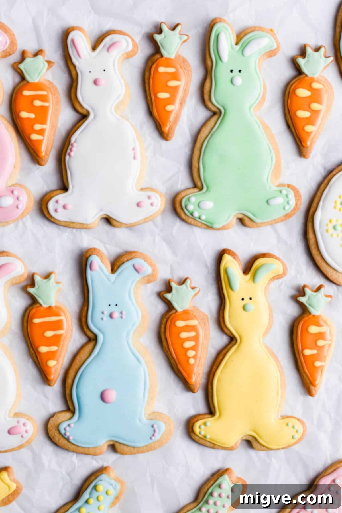 A delightful top view of bunny-shaped sugar cookies, charmingly decorated with pastel royal icing, arranged on a surface.