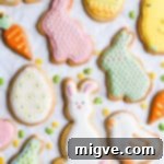 An overhead close-up of cookies in the festive shapes of bunnies and eggs, adorned with intricate icing details.