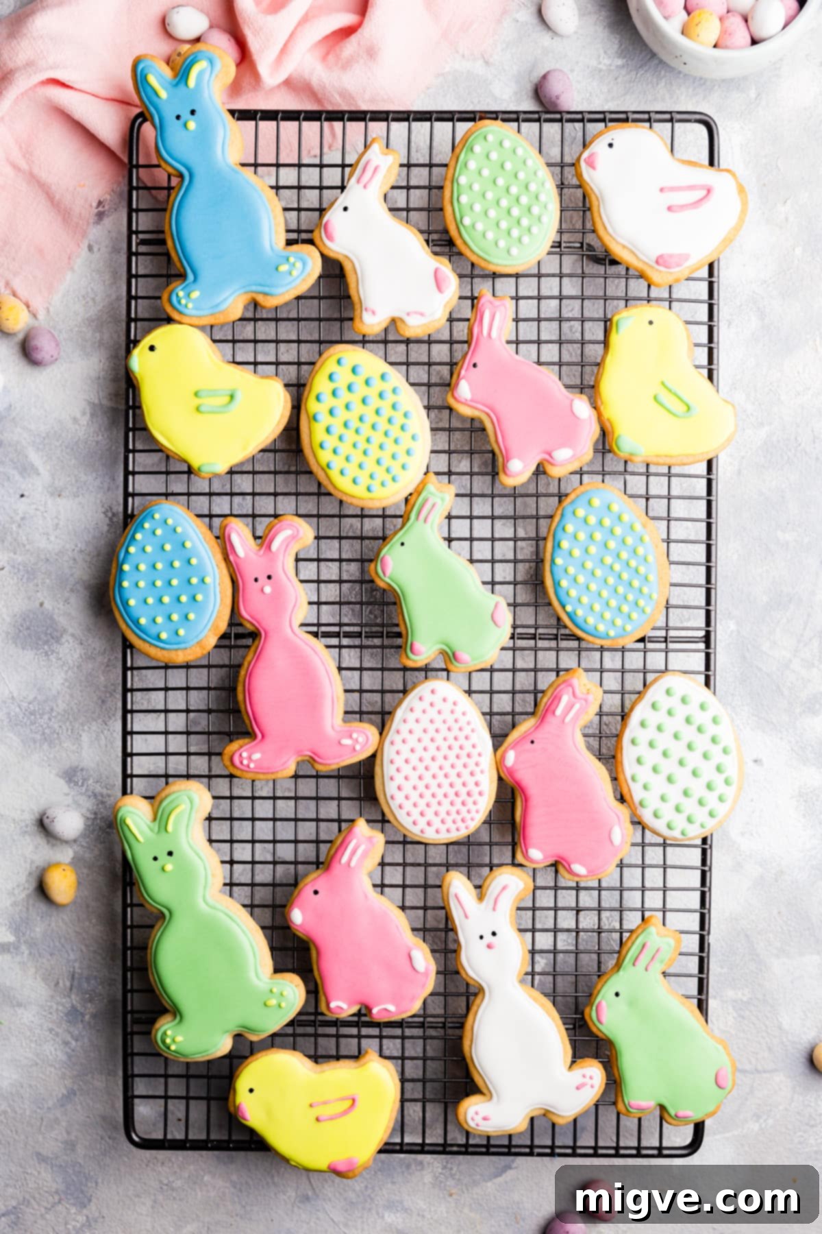 A stunning top-view arrangement of decorated Easter sugar cookies with royal icing, neatly placed on a wire rack to dry and set.