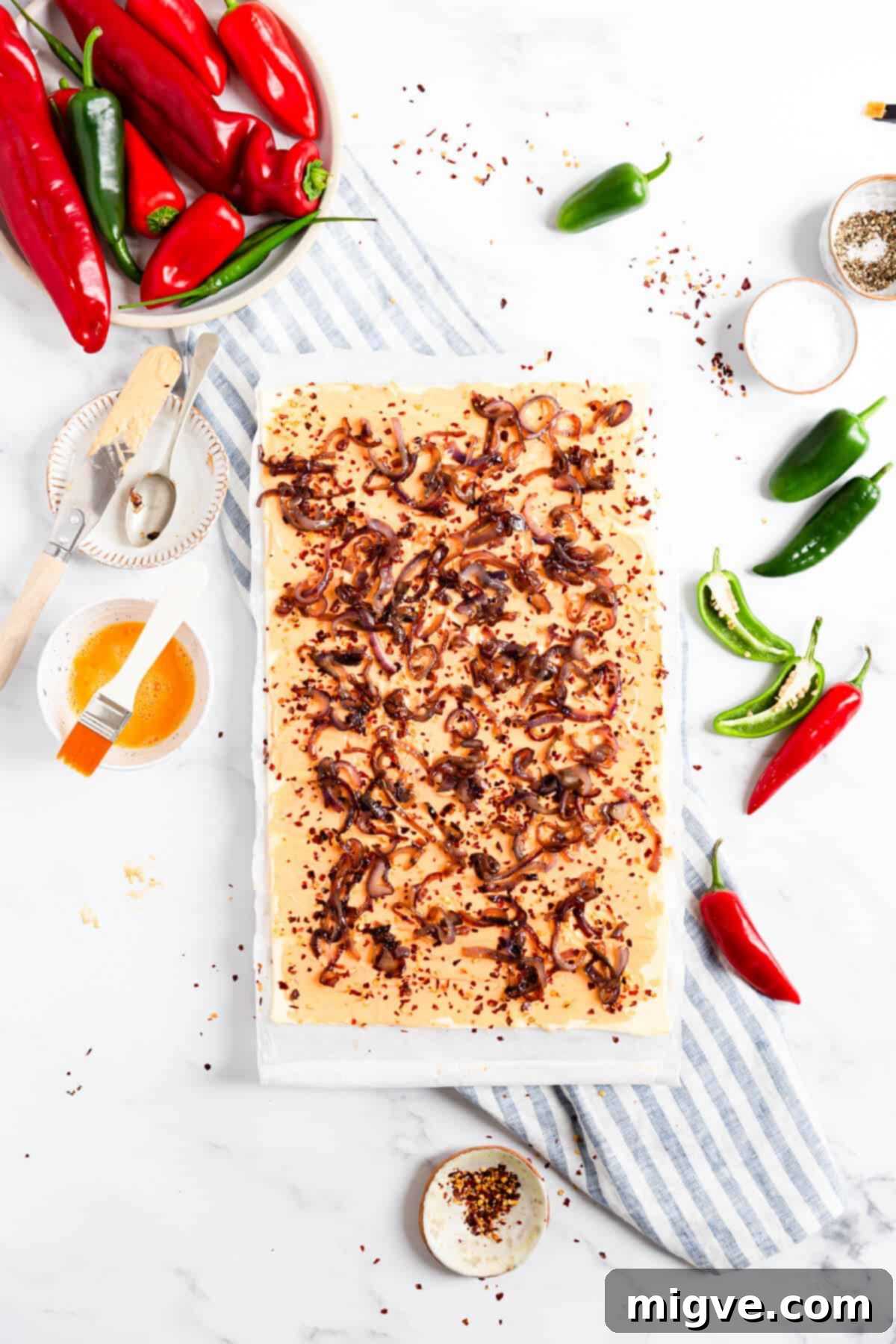 overhead shot of puff pastry sheet with cream cheese and caramelised onions