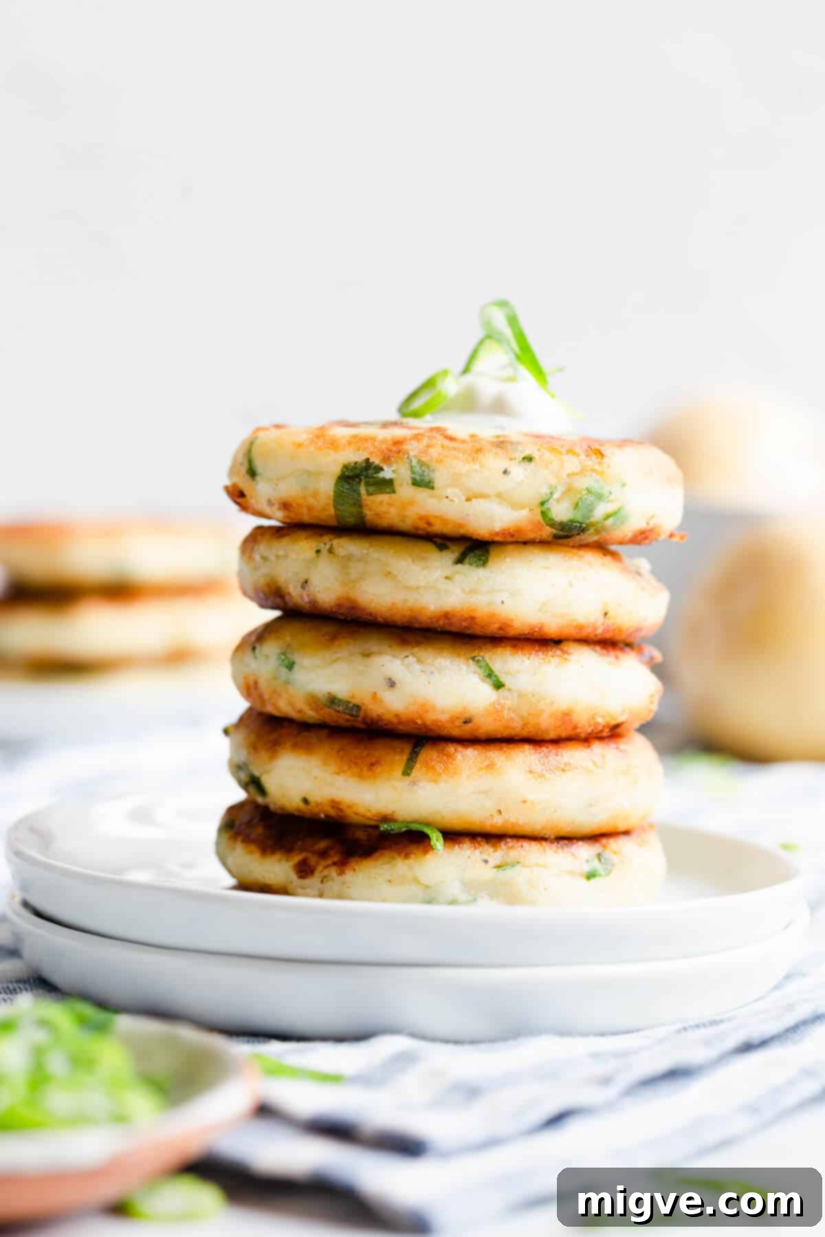 A straight-ahead close-up shot of five golden-brown potato patties, beautifully stacked, showcasing their crispy texture.