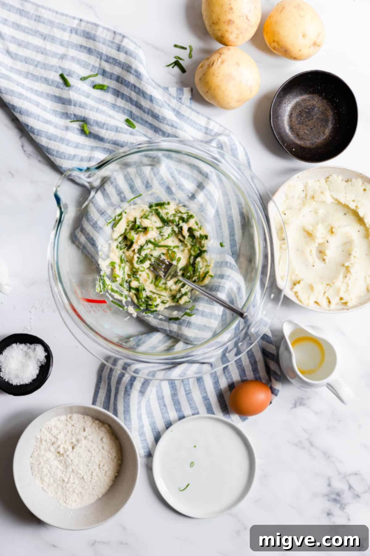 Top view of a bowl showing a well-mixed blend of egg, Parmesan, and chives, forming the base for the potato patties.