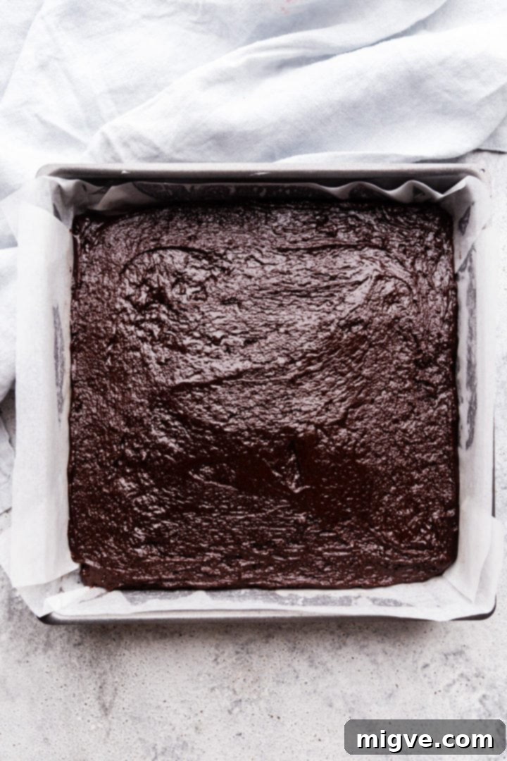 top view of the baking tin filled with brownie batter layer