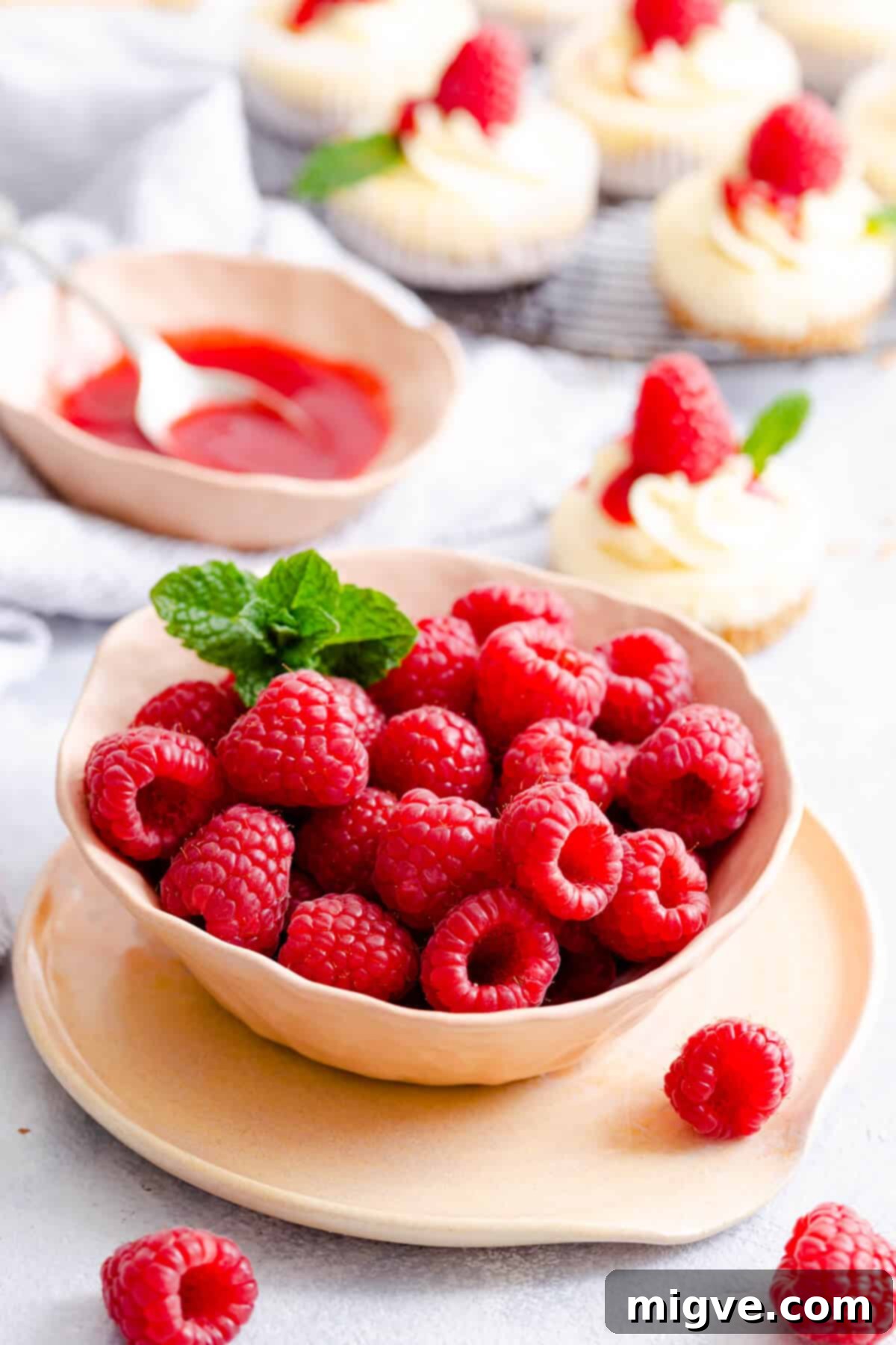 Cheesecake Bites 9 side angle close up of a bowl overflowing with fresh, ripe raspberries