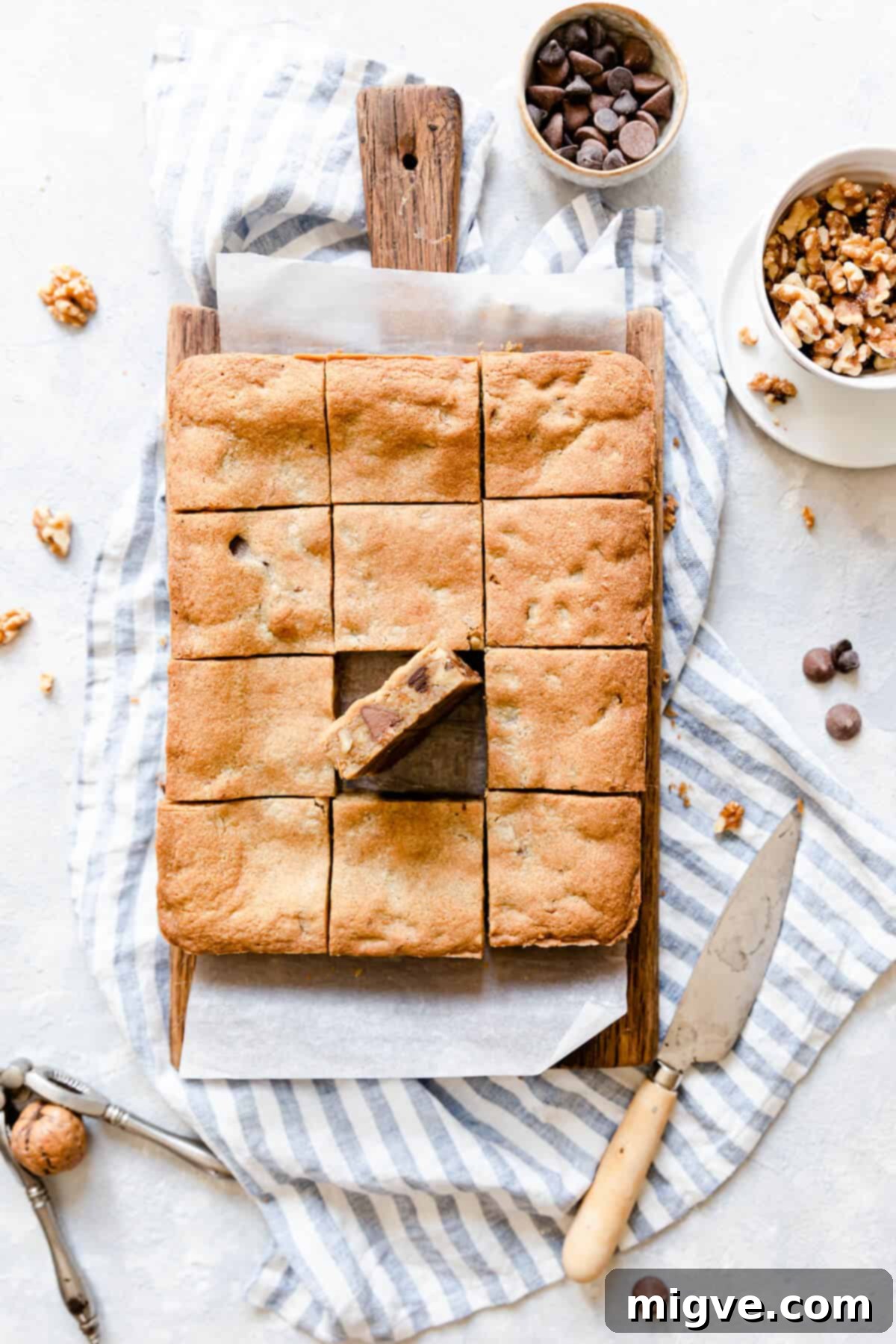 Chocolate Chip and Walnut Blondies 11 Top view of freshly baked chocolate and walnut blondies artfully arranged on a wooden chopping board