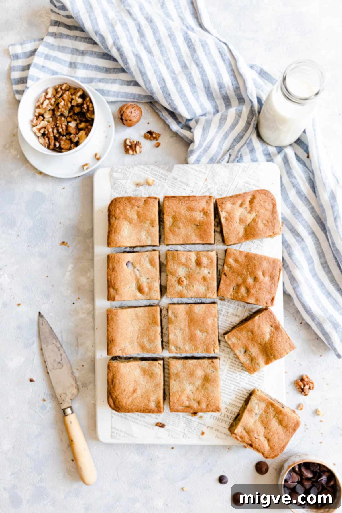 Chocolate Chip and Walnut Blondies 12 Top view of individually sliced blondie bars with chocolate chips and walnuts on a chopping board