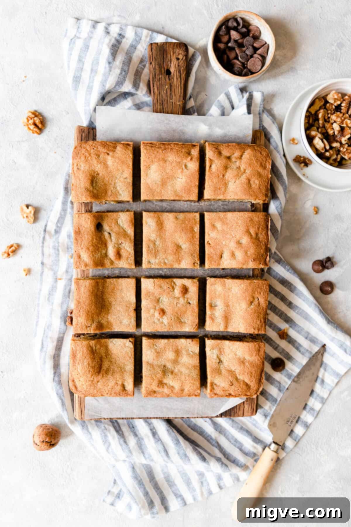 Chocolate Chip and Walnut Blondies 3 Top view of perfectly cut blondie squares arranged on a rustic wooden chopping board