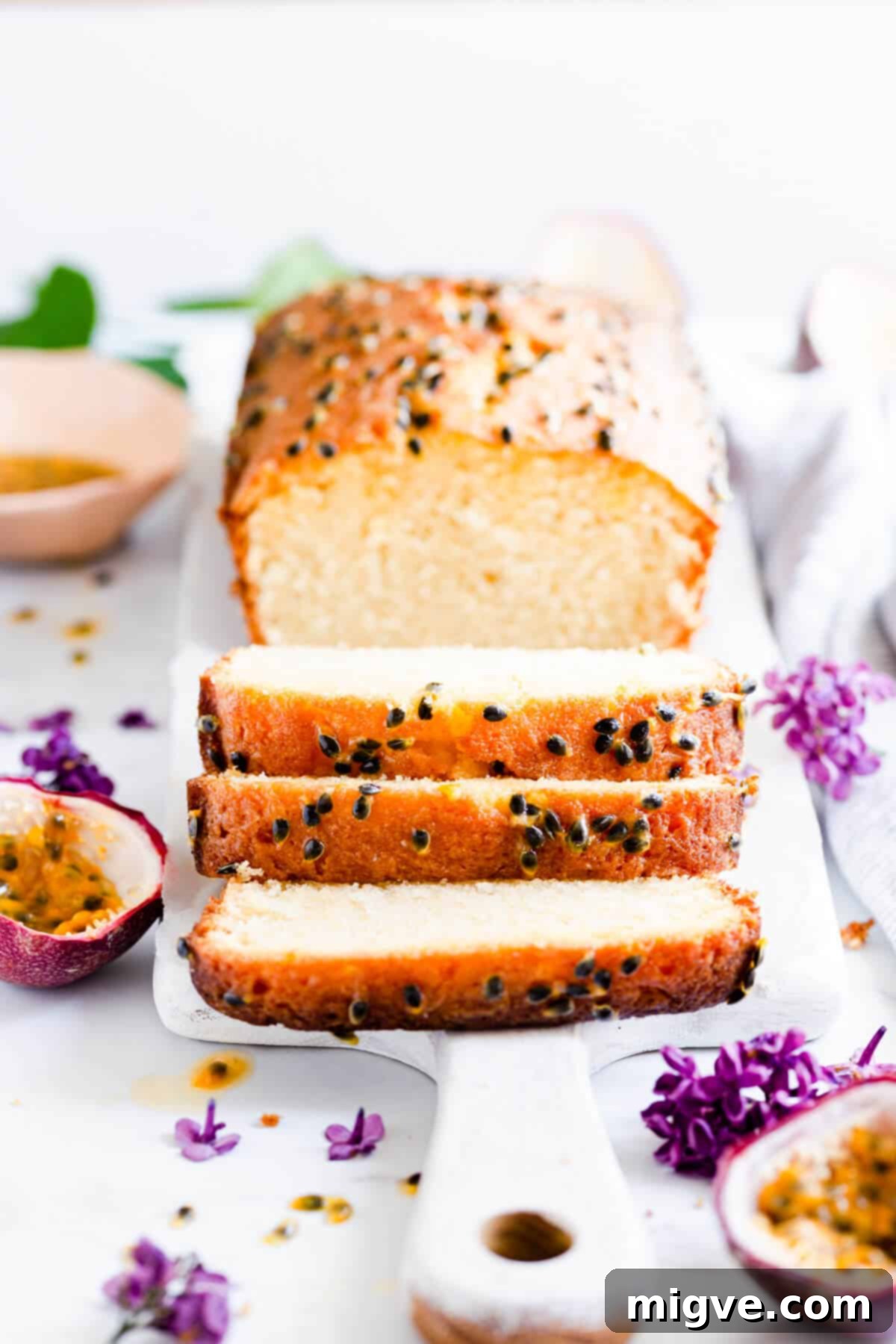 Tropical Passion Fruit Delight 2 Side view of multiple slices of moist passion fruit loaf cake with a tangy drizzle and sugared seeds on top
