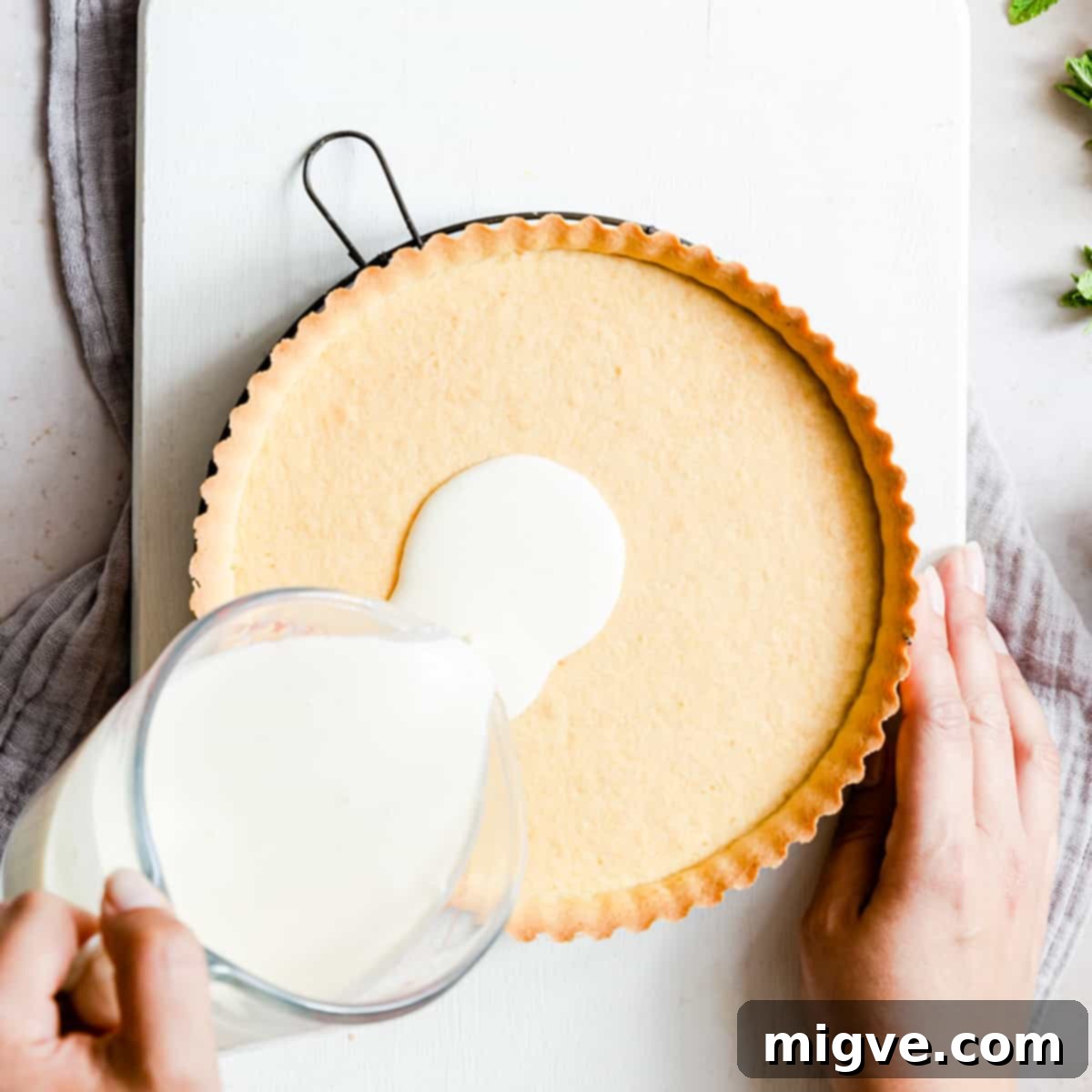 Velvet Raspberry Mascarpone Tart 6 mascarpone filling being poured into sweet pastry shell.