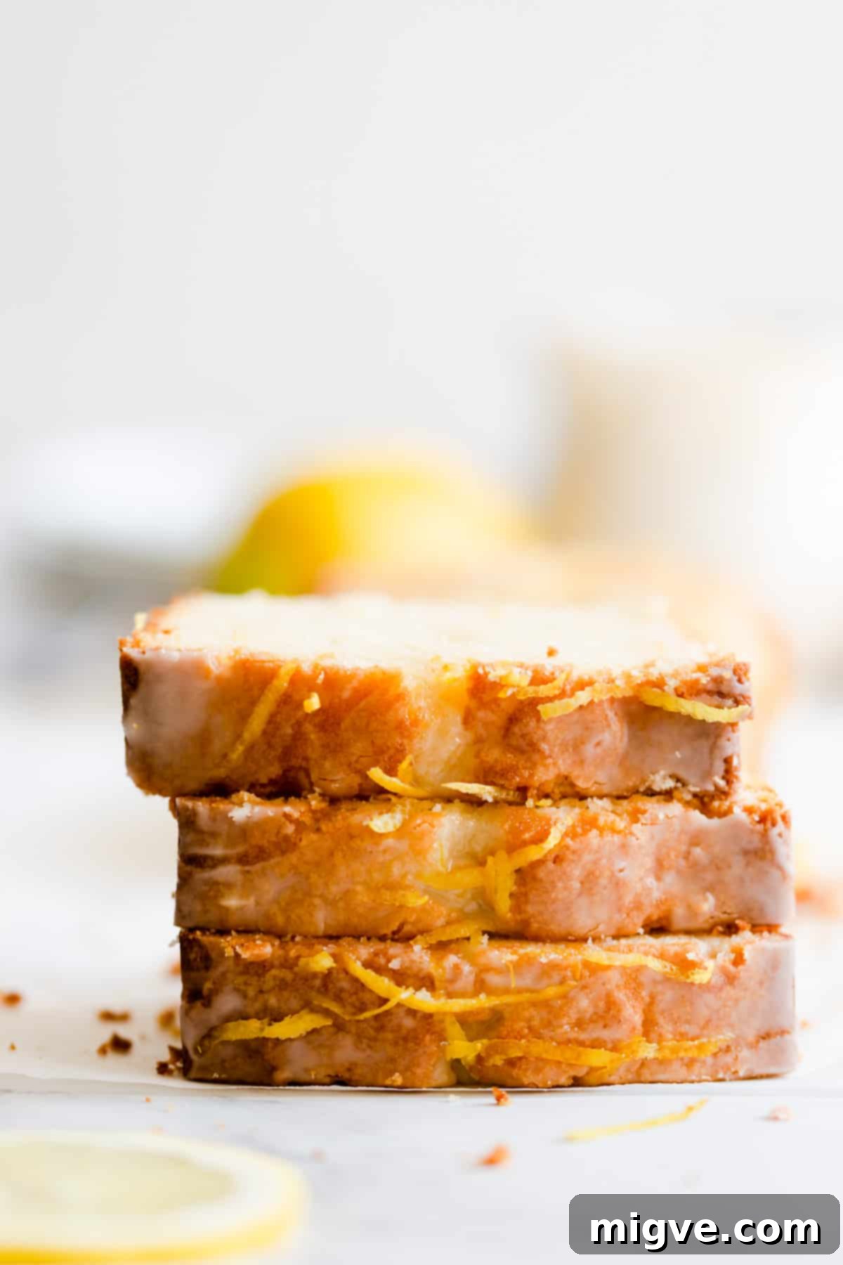 Zesty Small Batch Lemon Drizzle Cake 14 Side close-up of three slices of moist lemon drizzle cake, artfully stacked on top of each other, showcasing the perfect texture.