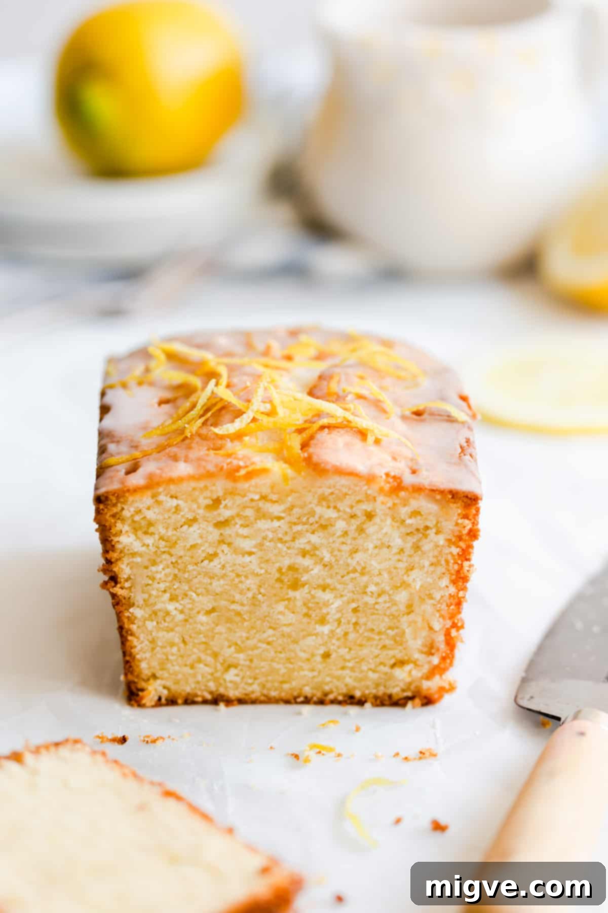 Zesty Small Batch Lemon Drizzle Cake 15 Straight-ahead shot of a small-batch lemon drizzle cake loaf with a slice removed, revealing the soft, moist interior and delicious glaze.