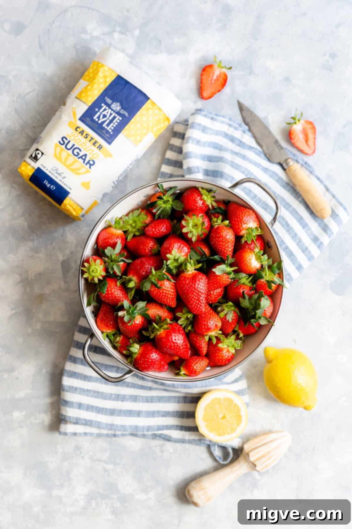 Effortless Strawberry Sunshine 6 top view at fresh strawberries in colander and some sugar and lemon on side