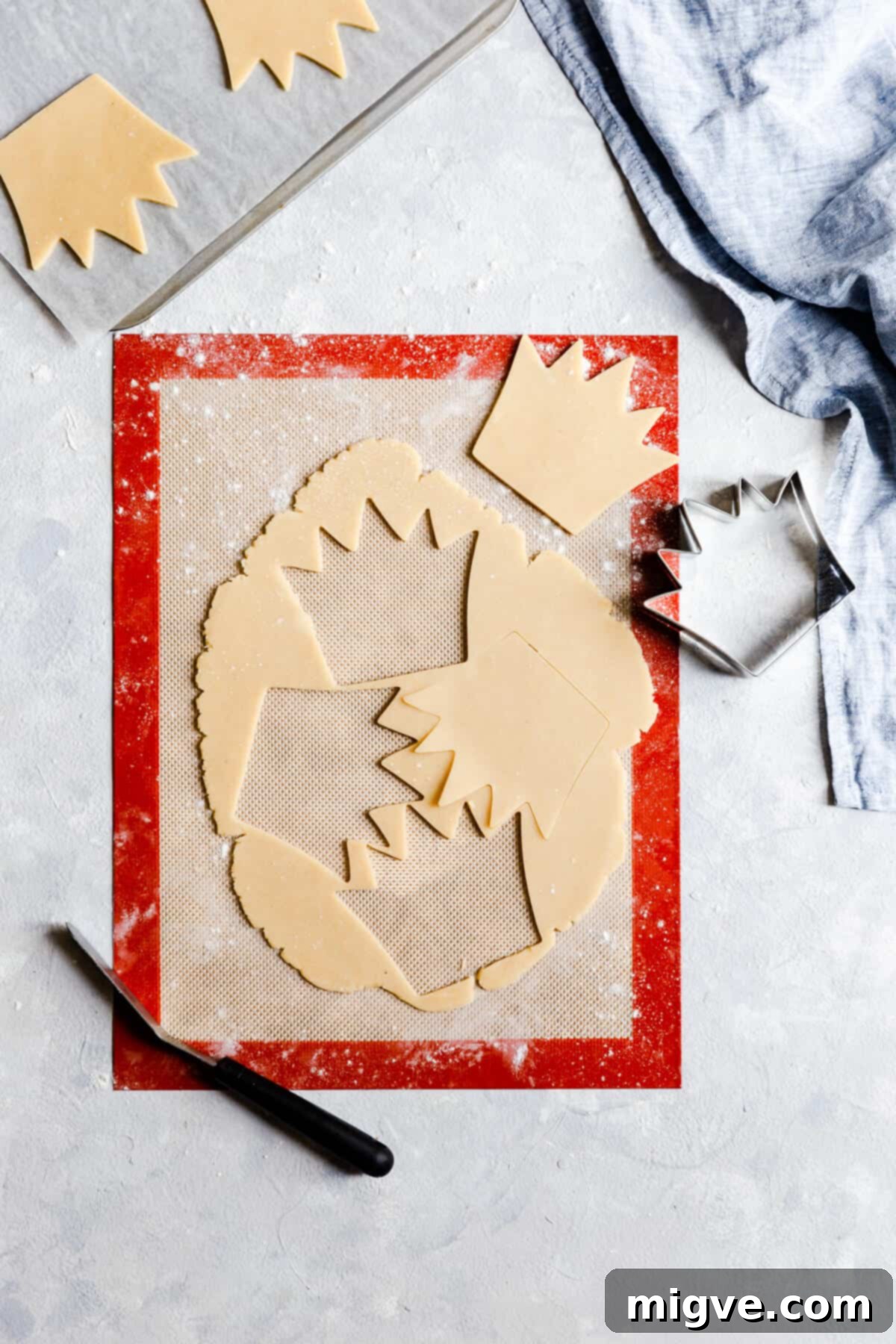Celebration Sugar Cookie Delights 11 Overhead view of rolled cookie dough after crown shapes have been neatly cut out, ready for baking.