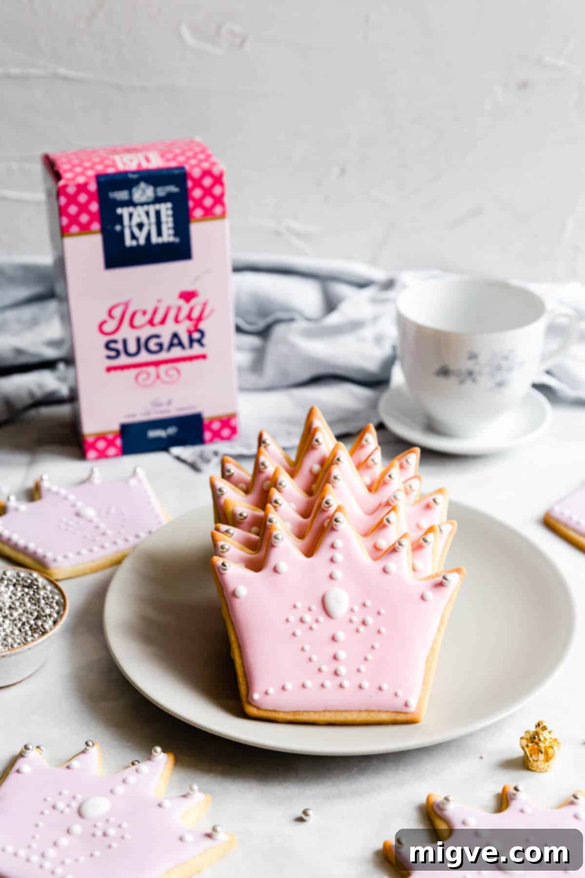 Celebration Sugar Cookie Delights 12 Side shot of perfectly baked and decorated crown-shaped sugar cookies, arranged delicately on a small grey plate.