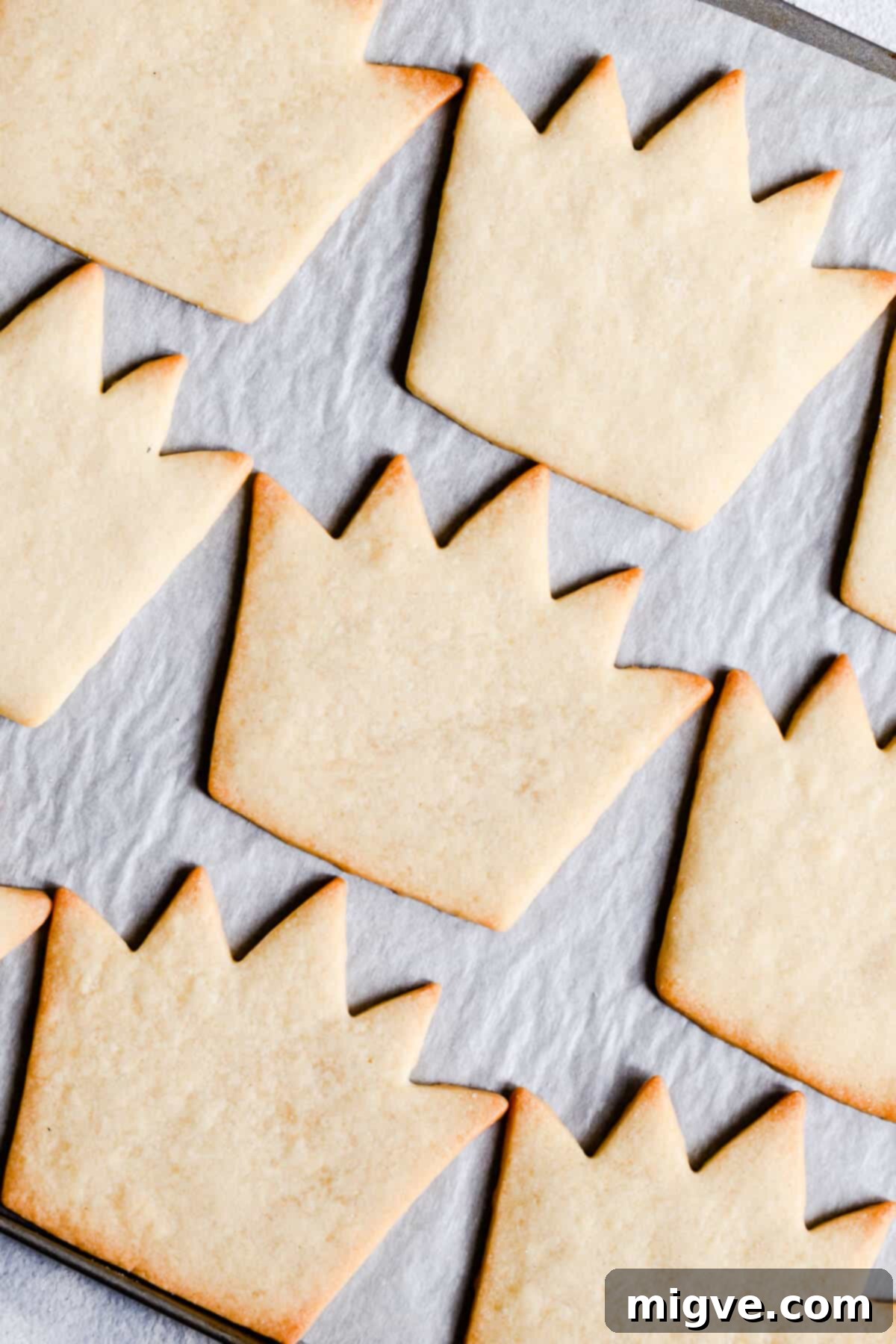 Celebration Sugar Cookie Delights 4 A close-up overhead shot of beautifully decorated crown-shaped birthday sugar cookies, showcasing intricate royal icing details.