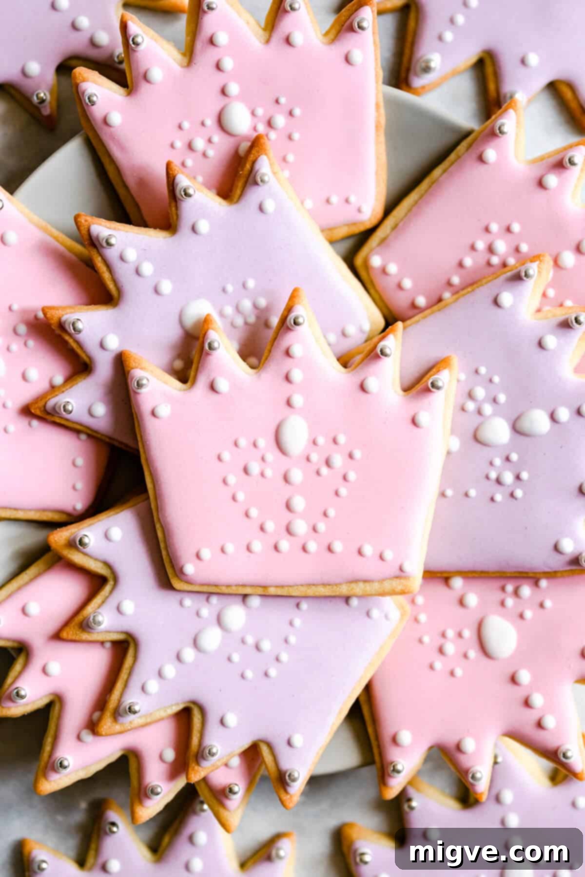 Celebration Sugar Cookie Delights 6 A super close-up image of beautifully decorated crown-shaped sugar cookies, showcasing the delicate details of the royal icing.