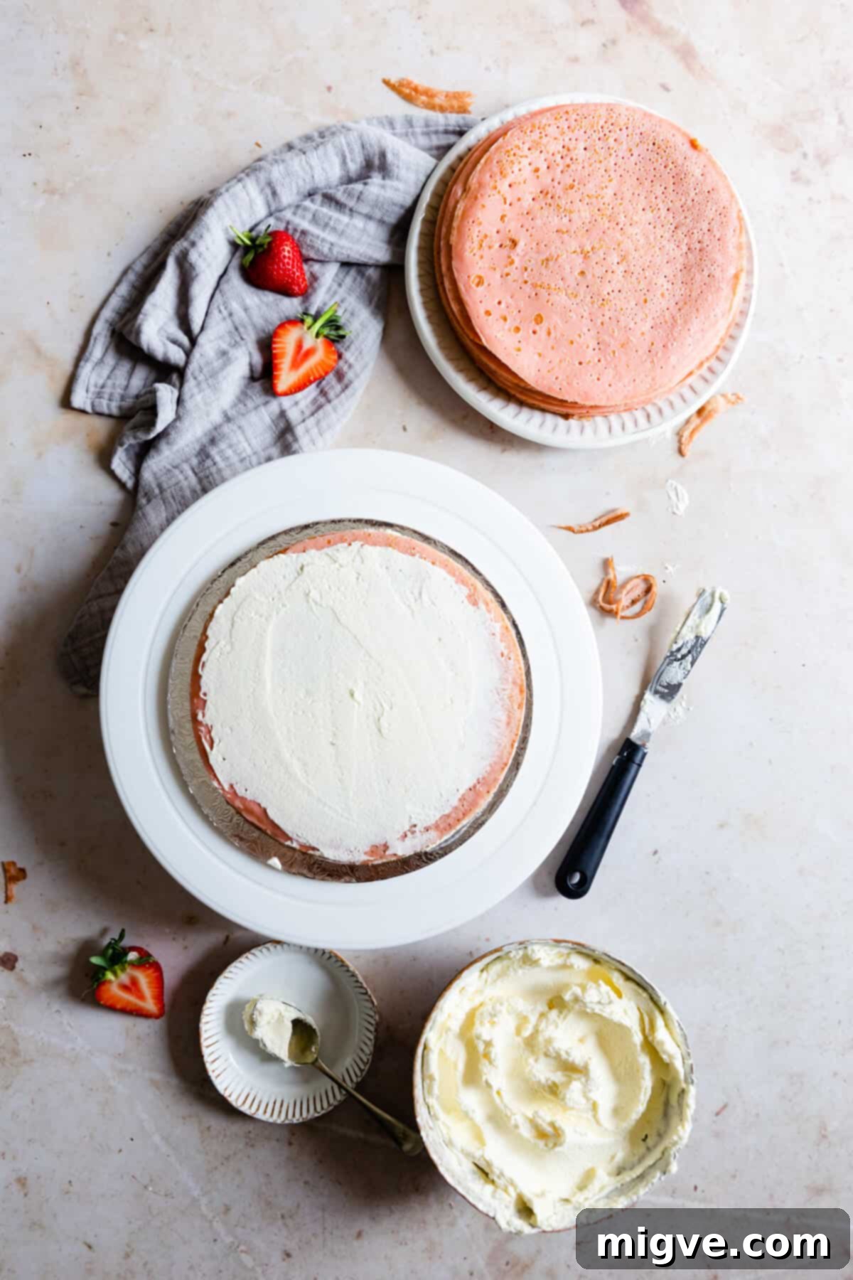overhead process shot showing whipped cream being spread on top of the crepe