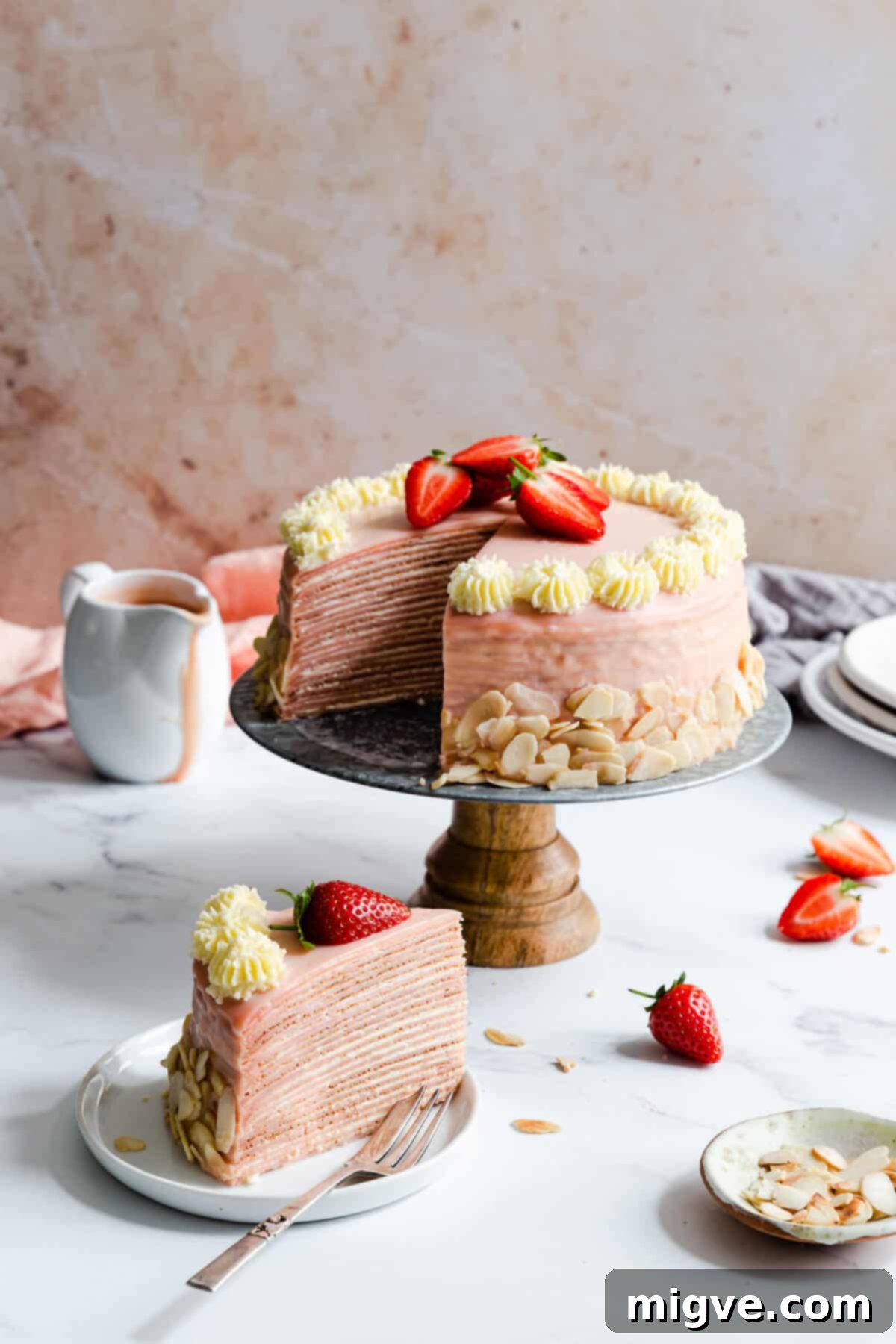 side angle of a slice of crepe cake on a small plate, with cake behind it